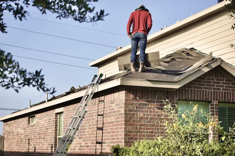 Professional roofer working on a residential roof in Mandan